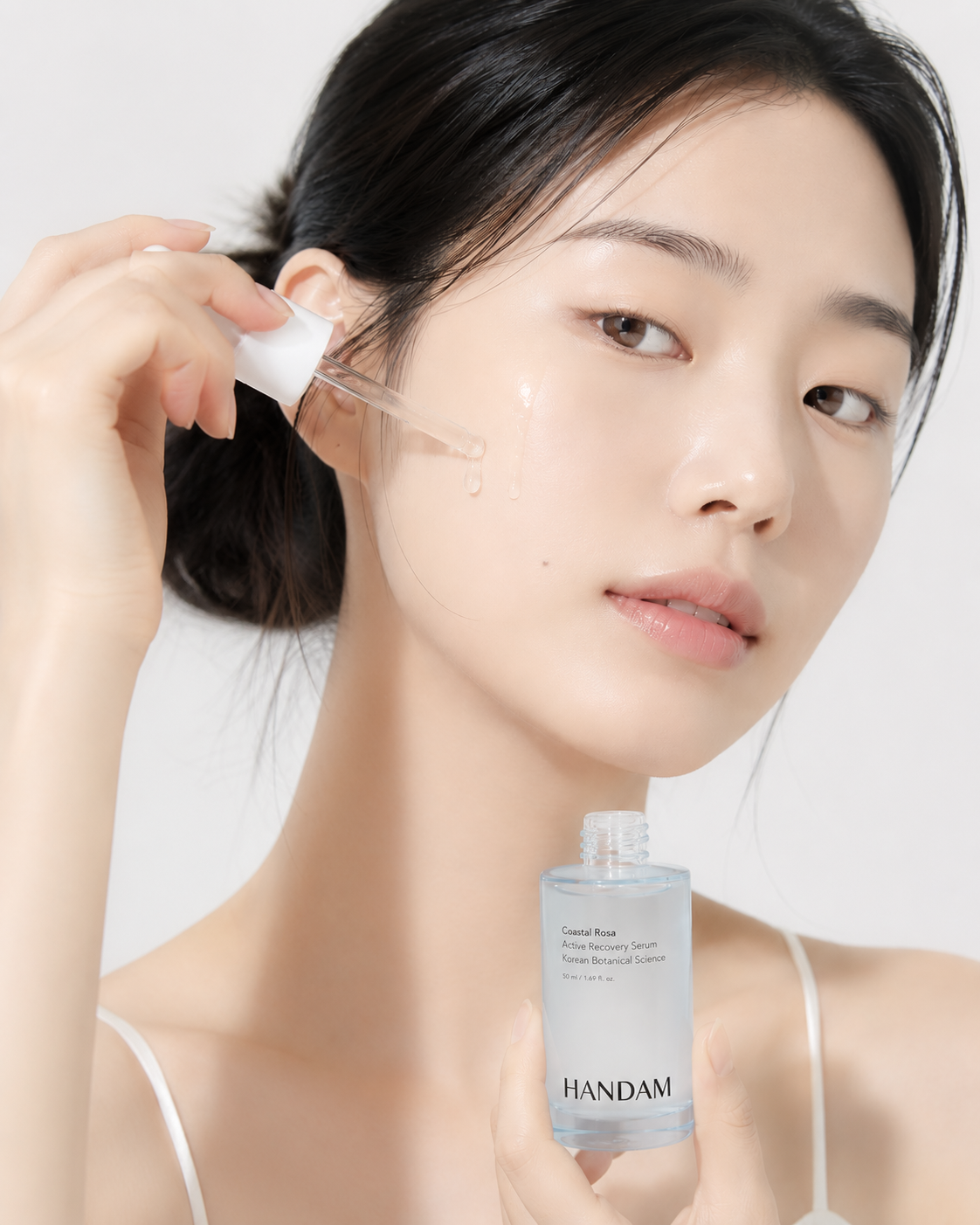 Model applying the Coastal Rosa serum to her face